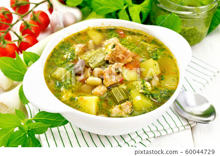 Soup with pisto sauce in bowl on light board 60044729