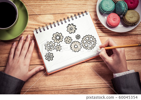Businesswoman sketching in notepad 60045354