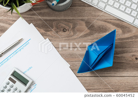 Modern office workspace with blue paper ship 60045452