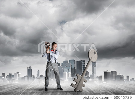 Breaking through access concept with furious man crashing concrete key 60045729