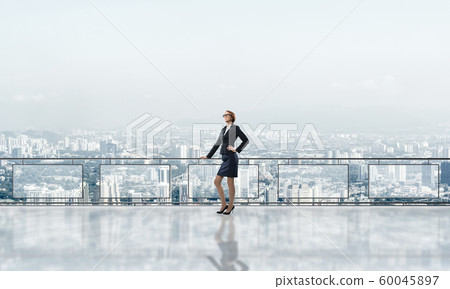 Sunrise above skyscrapers and businesswoman facing new day 60045897