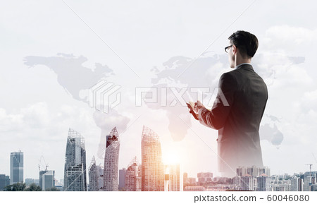 Concept of business success and control with confident boss against cityscape background 60046080