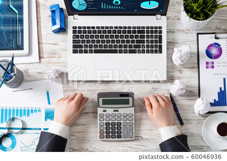 Businessman working at office desk with data Businessman working at office desk with data 60046936