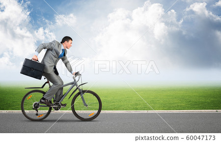 Young man riding bicycle on highway Young man riding bicycle on highway 60047173