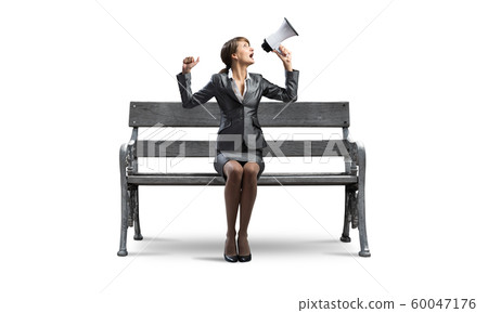 Young woman shouting into megaphone Young woman shouting into megaphone 60047176