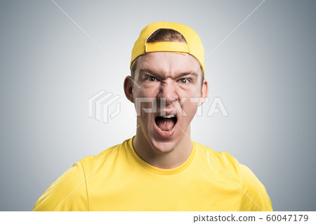 Frenzied teenager screaming with anger. 60047179