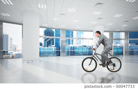 Businessman wearing business suit riding bicycle Businessman wearing business suit riding bicycle 60047733