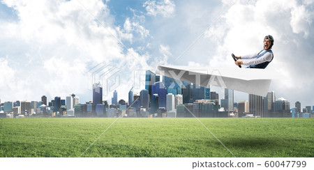 Young pilot sitting in big paper plane 60047799