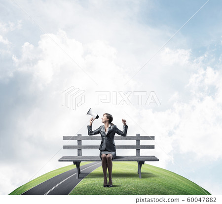 Business woman with megaphone on wooden bench 60047882