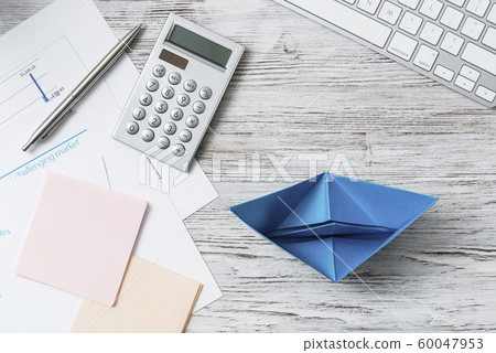 Modern office workspace with blue paper ship 60047953