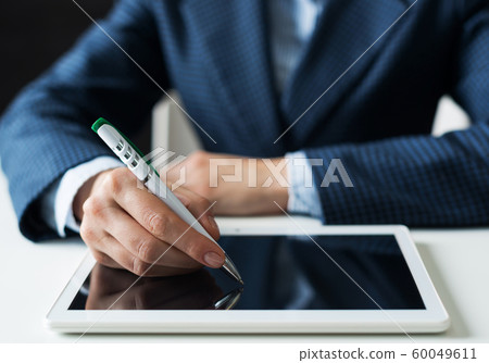 Man in business suit sitting at desk with tablet 60049611