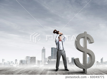 Determined banker man against modern cityscape breaking dollar concrete figure Determined banker man against modern cityscape breaking dollar concrete figure 60049771