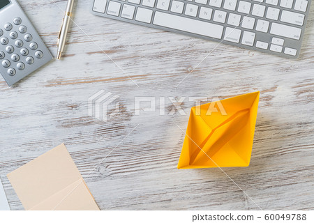 Modern office workspace with yellow paper ship Modern office workspace with yellow paper ship 60049788