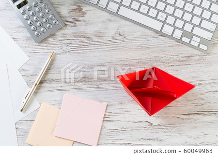 Top view office workspace with red paper ship 60049963