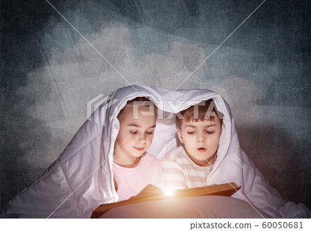 Engrossed little girl and boy reading book Engrossed little girl and boy reading book 60050681