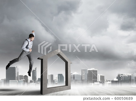 Manager man crashing stone home as symbol for real estate insurance Manager man crashing stone home as symbol for real estate insurance 60050689