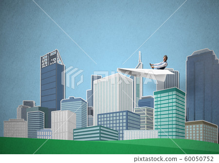 Businessman in aviator hat sitting in paper plane Businessman in aviator hat sitting in paper plane 60050752