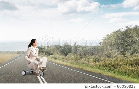 Beautiful caucasian woman riding kid's bicycle 60050822