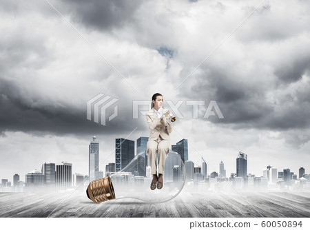 Attractive woman playing trumpet brass Attractive woman playing trumpet brass 60050894