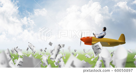 Businessman in aviator hat driving plane 60050897