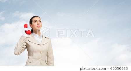 Young business woman holding red retro phone 60050953