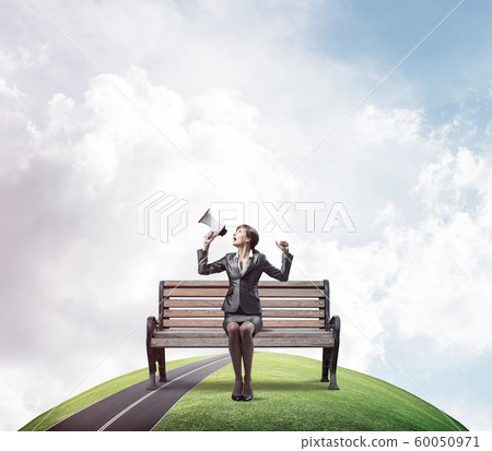 Business woman with megaphone on wooden bench Business woman with megaphone on wooden bench 60050971