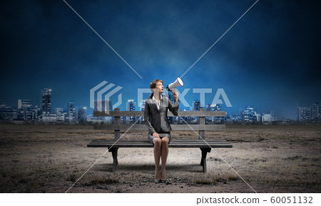 Business woman with megaphone on wooden bench Business woman with megaphone on wooden bench 60051132