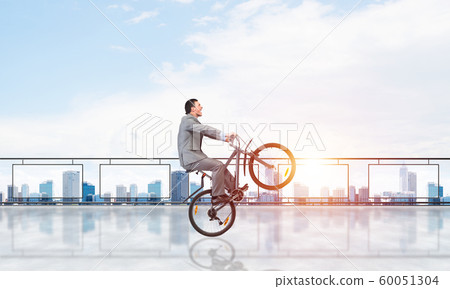 Man riding bicycle on penthouse balcony 60051304