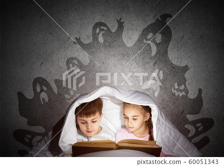 Engrossed little kids reading book in bed 60051343