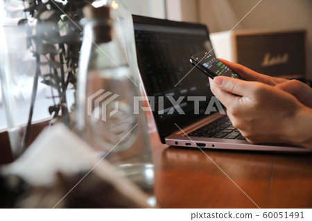 Female hand with smartphone trading stock online in coffee shop , Business concept Female hand with smartphone trading stock online in coffee shop , Business concept 60051491