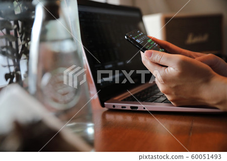 Female hand with smartphone trading stock online in coffee shop , Business concept Female hand with smartphone trading stock online in coffee shop , Business concept 60051493