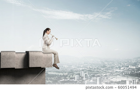 Elegant young woman playing trumpet Elegant young woman playing trumpet 60051494