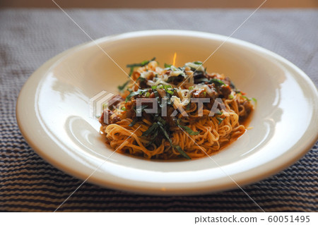 spaghetti Bolognese with minced beef and tomato sauce garnished with parmesan cheese and basil , Italian food 60051495