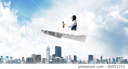Aviator driving paper plane above business center 60051711