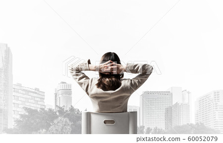 Woman holding hands behind head 60052079