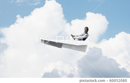 Pilot in leather helmet driving paper plane Pilot in leather helmet driving paper plane 60052080