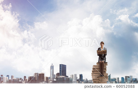 Smiling woman holding open book Smiling woman holding open book 60052088