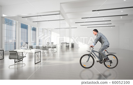 Businessman wearing business suit riding bicycle Businessman wearing business suit riding bicycle 60052100