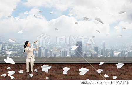 Elegant young woman playing trumpet Elegant young woman playing trumpet 60052146