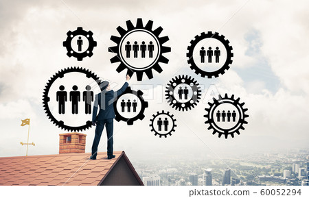 Businessman on house roof presenting teamwork and connection con Businessman on house roof presenting teamwork and connection con 60052294
