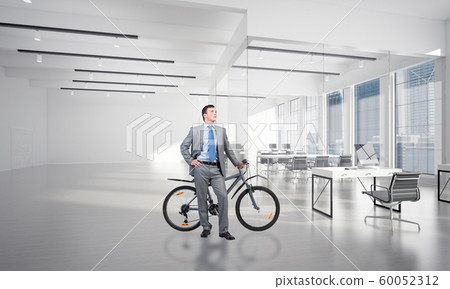 Smiling man in business suit standing with bike Smiling man in business suit standing with bike 60052312