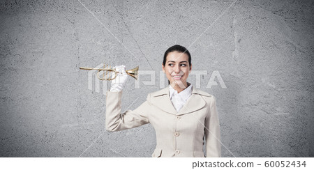 Beautiful woman holding trumpet brass near ear 60052434