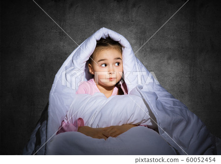 Frightened girl hiding under blanket Frightened girl hiding under blanket 60052454