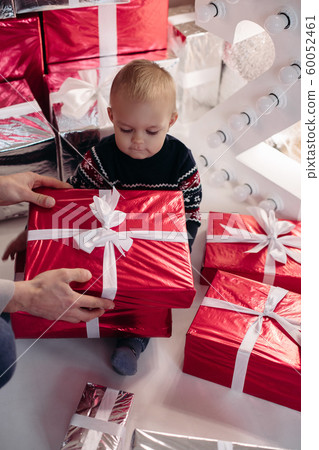 Cute boy in sweater with wrapped red Christmas 60052461