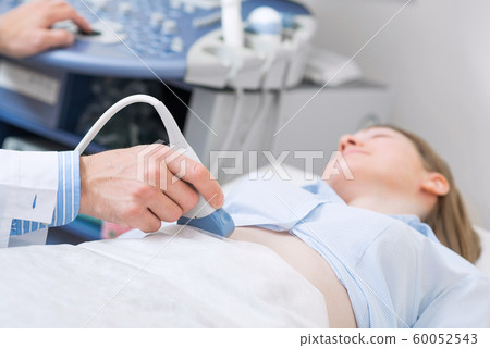 Sonographer using ultrasound machine at work 60052543