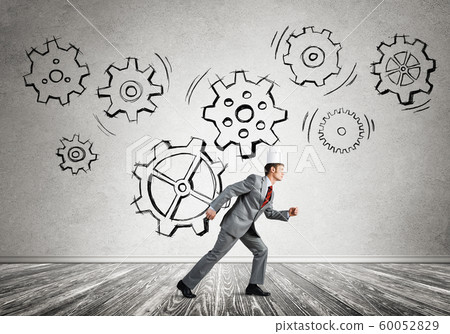 King businessman in elegant suit running in empty room with wooden floor King businessman in elegant suit running in empty room with wooden floor 60052829