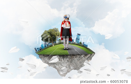 Girl power concept with cute kid guardian against cityscape background 60053078