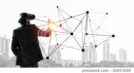 Handsome businessman experiencing impressive virtual reality connection concept Handsome businessman experiencing impressive virtual reality connection concept 60053098