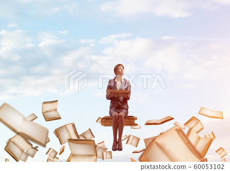 Smiling woman holding open book 60053102