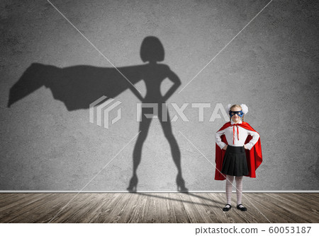 Girl power concept with cute kid guardian and shadow at wall. Mixed media Girl power concept with cute kid guardian and shadow at wall. Mixed media 60053187